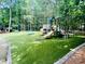 View of a community playground with modern play structures and padded green turf at 12702 Overlook Mountain Dr, Charlotte, NC 28216