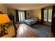 Comfortable bedroom features hardwood floors, two large windows, and calming blue accents at 13828 Lake Bluff Dr, Matthews, NC 28105