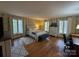 Bright bedroom showcasing hardwood floors, three large windows, and soothing neutral tones at 13828 Lake Bluff Dr, Matthews, NC 28105