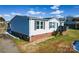 Home exterior featuring vinyl siding, brick foundation, walkway and wooden front deck with chairs at 1868 Ellick Dr, Newton, NC 28658