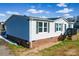 Home exterior featuring vinyl siding, brick foundation, walkway and wooden front deck with chairs at 1868 Ellick Dr, Newton, NC 28658