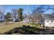 This backyard features a grassy lot, multiple mature trees, and a sitting area surrounding a small fire pit at 206 Mcconnell St, Clover, SC 29710