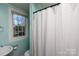 This full bathroom features a white sink, toilet, black shower curtain rod, and a view of the outdoors at 206 Mcconnell St, Clover, SC 29710