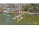 Aerial view of a lake house featuring a private dock, surrounded by lush greenery and serene waters at 2139 Peninsula Dr, Clover, SC 29710