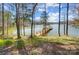 Lake view backyard with private dock surrounded by trees and lush lawn at 2139 Peninsula Dr, Clover, SC 29710
