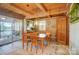 Cozy dining area with wood table, chairs, bench, and access to a screened-in porch with lake view at 2139 Peninsula Dr, Clover, SC 29710