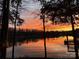 Beautiful waterfront sunset view with dock, trees and water reflection of the golden orange sky at 2139 Peninsula Dr, Clover, SC 29710