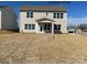 View of the backyard of a beige two-story home with a small, covered patio and ample lawn at 2216 Camber Dr # Cwo0074, Gastonia, NC 28054