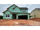 New home under construction with green weather resistant wrap, windows installed, and attached garage at 2216 Camber Dr # Cwo0074, Gastonia, NC 28054