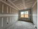 Living room under construction with visible wall studs and concrete flooring with a window offering natural light at 2216 Camber Dr # Cwo0074, Gastonia, NC 28054