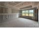 Living room under construction with visible wall studs and concrete flooring with a large window offering natural light at 2216 Camber Dr # Cwo0074, Gastonia, NC 28054