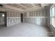 Living room under construction with visible wall studs and concrete flooring and a large window offering natural light at 2216 Camber Dr # Cwo0074, Gastonia, NC 28054