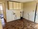 Kitchen awaiting renovation, featuring hardwood floors and upper cabinet storage at 2609 E Greenbriar Rd, Statesville, NC 28625