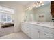 Bright bathroom with double vanity, white cabinets and a neutral color palette at 2937 Bellasera Way, Matthews, NC 28105