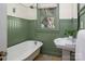 Charming bathroom featuring beadboard walls, a classic pedestal sink, and a vintage-style clawfoot tub at 316 S Summit Ave, Charlotte, NC 28208