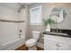 Bathroom with a bathtub, white tile, and a stylish vanity at 316 S Summit Ave, Charlotte, NC 28208