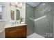 Updated bathroom with a wood vanity, white countertop, vertical tiles and a shower at 316 S Summit Ave, Charlotte, NC 28208