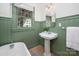 Charming bathroom featuring beadboard walls, a classic pedestal sink, and a vintage-style clawfoot tub at 316 S Summit Ave, Charlotte, NC 28208