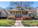 Charming home featuring a brick front porch and stairs, complemented by a well-manicured lawn and classic architectural details at 316 S Summit Ave, Charlotte, NC 28208