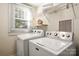 Bright laundry room with a side-by-side washer and dryer, shelf, and window at 316 S Summit Ave, Charlotte, NC 28208