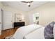 Bright bedroom with hardwood floors, white bedding, and a black dresser at 316 S Summit Ave, Charlotte, NC 28208