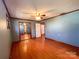 Bedroom with wood floor, ceiling fan, and a mirrored closet for ample storage at 4069 Amsbury Rd, Concord, NC 28025