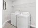 A laundry room features white washer and dryer set, with wire shelving above, and neutral flooring at 414 Glencroft Dr, Wingate, NC 28174