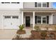 Close-up of the home's inviting front porch and a two-car garage at 418 Babbling Brook Ln # 245B, Locust, NC 28097