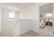 Carpeted upstairs hallway leading to a naturally lit bedroom with neutral decor at 418 Babbling Brook Ln # 245B, Locust, NC 28097