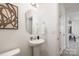 Charming powder room features pedestal sink, decorative mirror and convenient access to the kitchen at 418 Babbling Brook Ln # 245B, Locust, NC 28097
