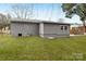 Backyard view of grey home featuring a large, grassy yard at 4501 Knollcrest Dr, Charlotte, NC 28208