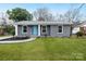 Charming single story house with a well maintained lawn and a light blue front door at 4501 Knollcrest Dr, Charlotte, NC 28208