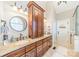Bathroom featuring double vanity with granite counters, decorative fixtures, and a large storage cabinet at 4552 Sawgrass Ct, Denver, NC 28037