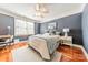 Bedroom featuring hardwood floors, ceiling fan, and natural light from a large window at 4552 Sawgrass Ct, Denver, NC 28037