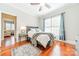 Comfortable bedroom featuring hardwood floors, ceiling fan, and natural light from a large window at 4552 Sawgrass Ct, Denver, NC 28037