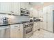 Close-up view of a modern stainless steel oven, cooktop, and white cabinets at 4552 Sawgrass Ct, Denver, NC 28037
