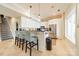 Modern kitchen with white cabinets, stainless steel appliances, breakfast bar, and adjacent staircase at 4552 Sawgrass Ct, Denver, NC 28037