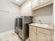 Functional laundry room with a sink, cabinets, and modern washer and dryer at 4552 Sawgrass Ct, Denver, NC 28037