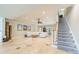 Large living room with tile floors and staircase, featuring a comfortable white sectional and a unique coffee table at 4552 Sawgrass Ct, Denver, NC 28037