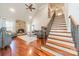 Open-concept living room with a stone fireplace, high ceilings, and hardwood floors at 4552 Sawgrass Ct, Denver, NC 28037