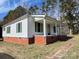 A cozy single-story home with a welcoming front porch and lush greenery surrounding the property at 5135 Tucker Ave, Kannapolis, NC 28081