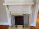 A close-up view of the fireplace and mantle with view into the kitchen and chandelier at 5135 Tucker Ave, Kannapolis, NC 28081