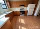 Functional kitchen with oak cabinets, white appliances, and vinyl flooring at 5135 Tucker Ave, Kannapolis, NC 28081