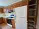 Functional kitchen featuring oak cabinets, white appliances and laminate flooring at 5135 Tucker Ave, Kannapolis, NC 28081