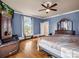 Cozy bedroom featuring blue walls, wood floors, ceiling fan, and a window view at 528 Sherrill Ave, Lincolnton, NC 28092