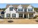 Charming two-story home featuring a welcoming front porch with stone accents and a well-manicured lawn at 702 Yucatan Dr, Waxhaw, NC 28173