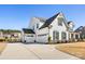 Beautiful two-story white home with a three-car garage and well-manicured landscaping at 702 Yucatan Dr, Waxhaw, NC 28173