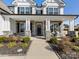 Inviting front porch showcasing stone pillars, a festive wreath, and outdoor seating at 702 Yucatan Dr, Waxhaw, NC 28173