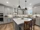 Bright kitchen features gray cabinets, a spacious island with seating, and modern pendant lighting at 702 Yucatan Dr, Waxhaw, NC 28173