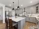 Gourmet kitchen featuring gray cabinets, quartz countertops, stainless appliances, and an island with seating at 702 Yucatan Dr, Waxhaw, NC 28173